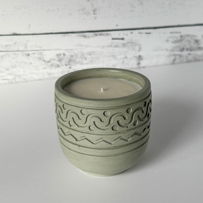 Forest Calm Candle with design on side of moss colored concrete jar.
