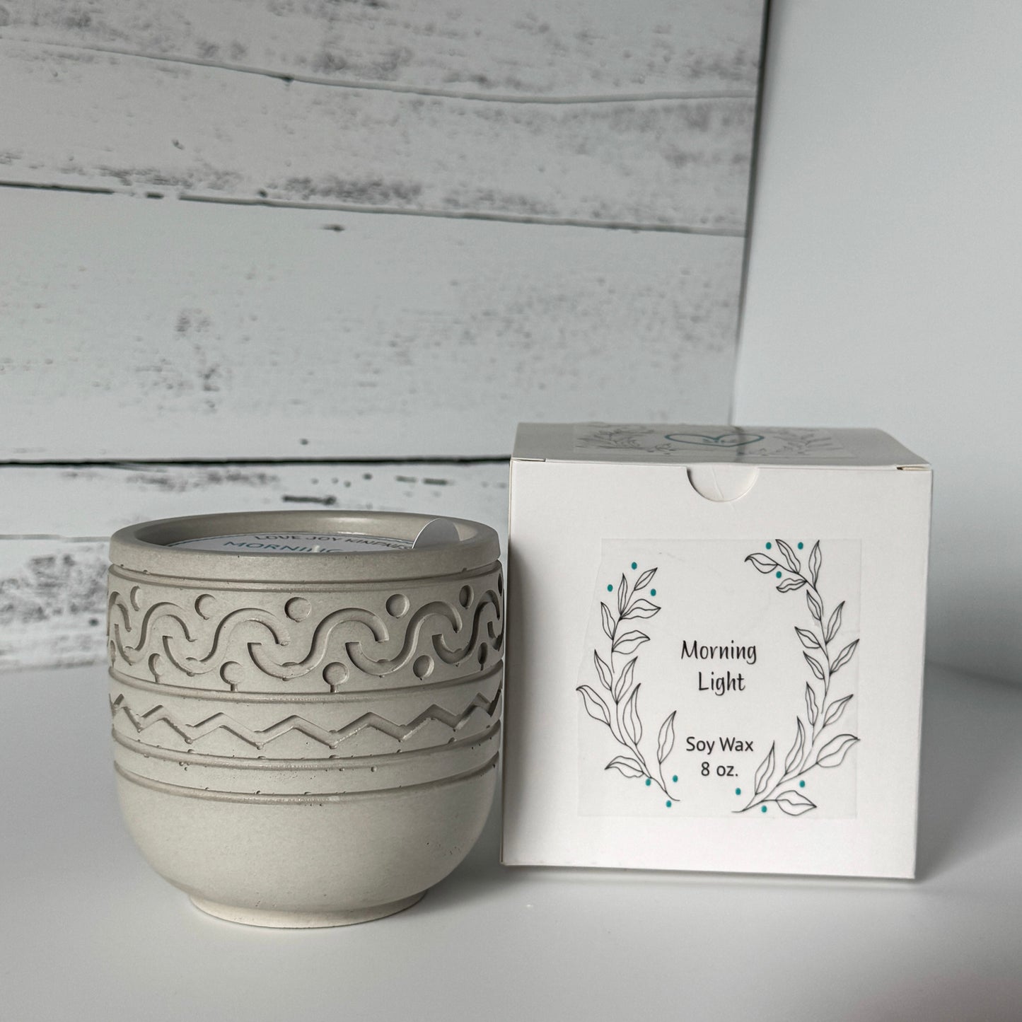 Morning Light Candle in gray concrete jar with packaging in background